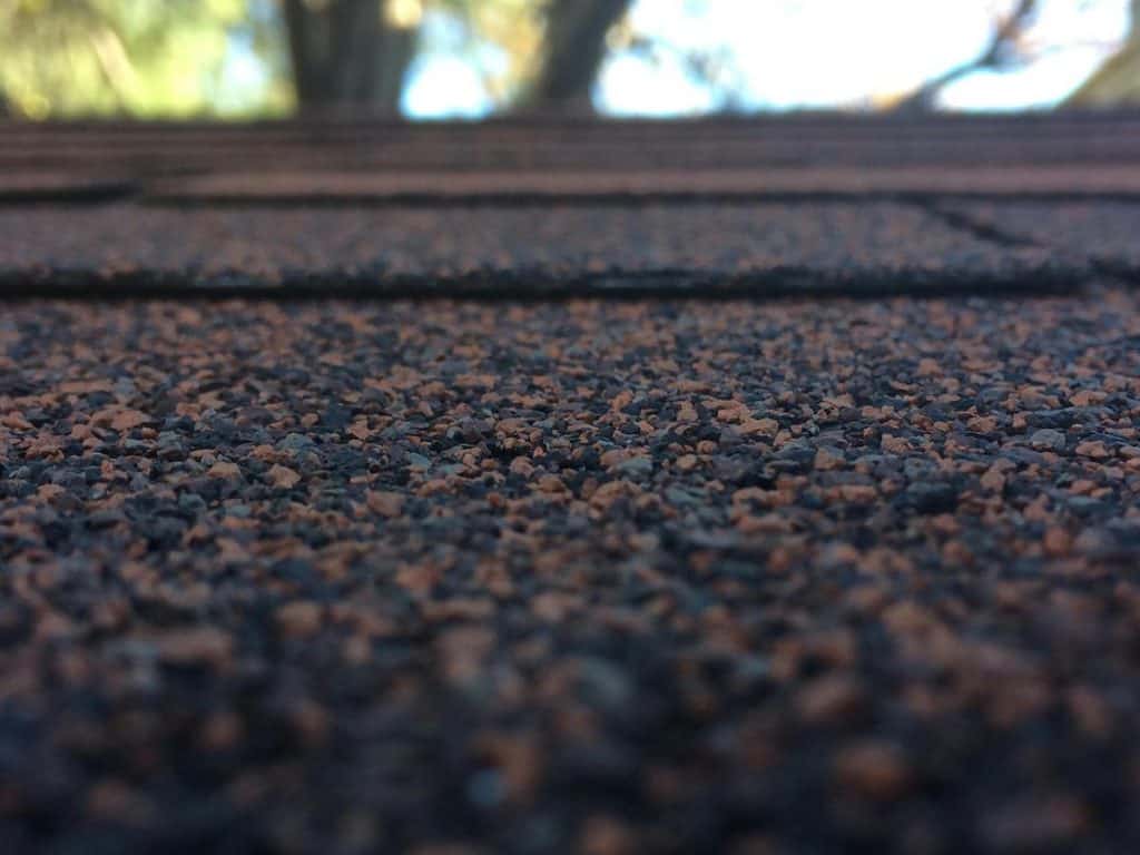 Soft wash roof cleaning in St Thomas removing moss and algae from shingles.